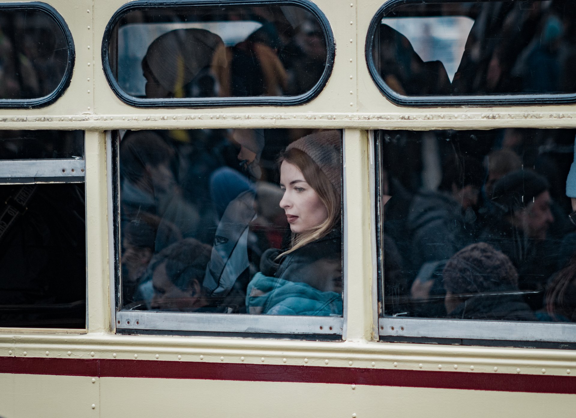 A girl looks out the window while sitting in an old tram.