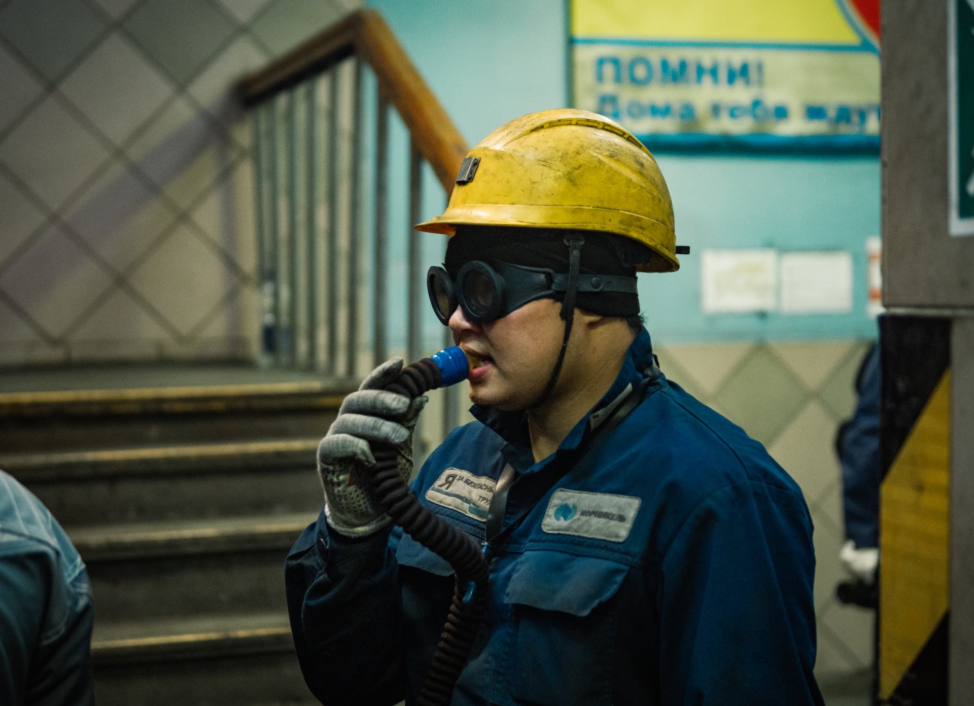 A copper factory worker breathes through an oxygen cylinder after working in the workshop. All workers have already been given new respirators for work, but many continue to breathe in this way out of habit.