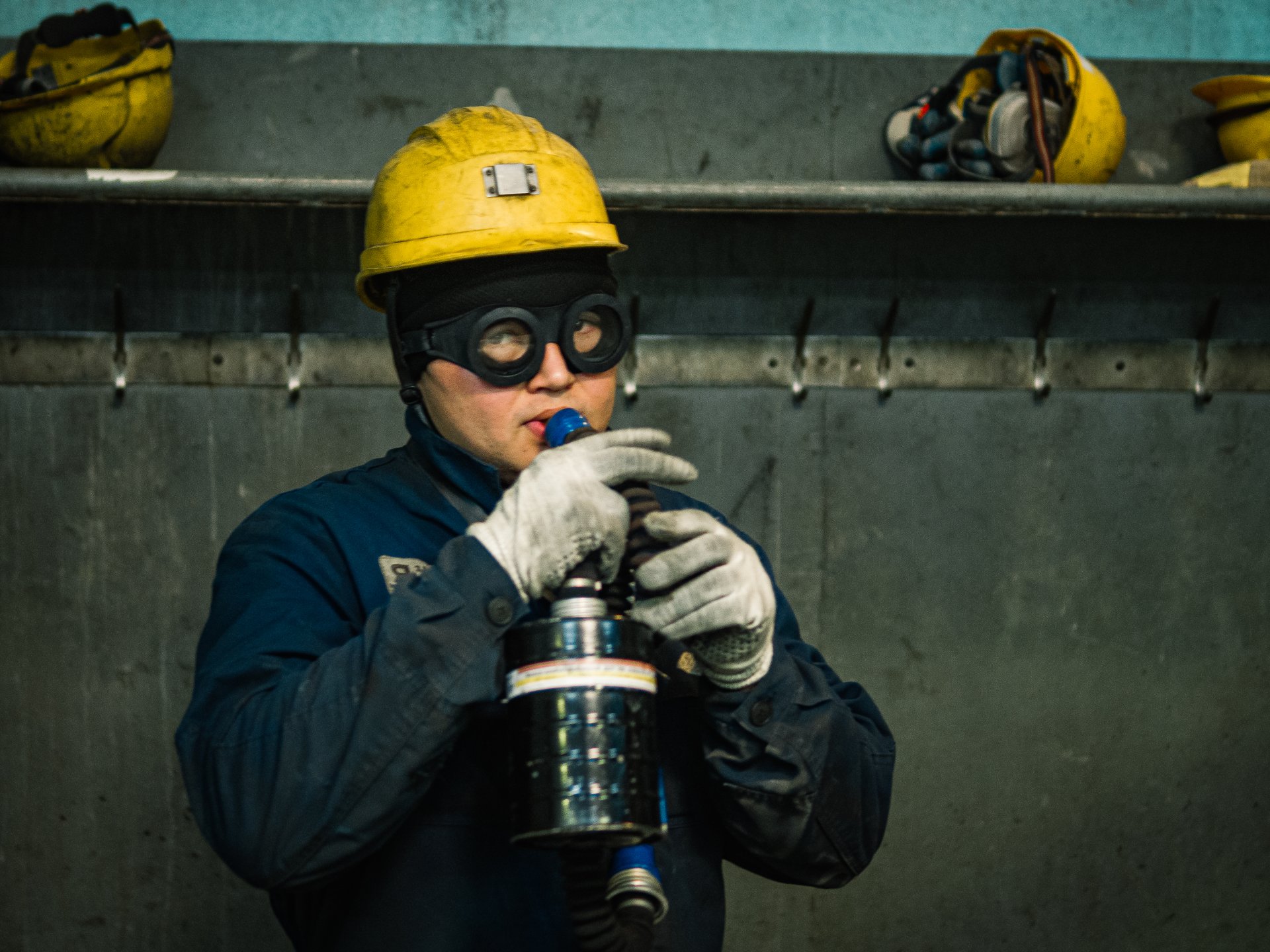 A copper factory worker breathes through an oxygen cylinder after working in the workshop. All workers have already been given new respirators for work, but many continue to breathe in this way out of habit.