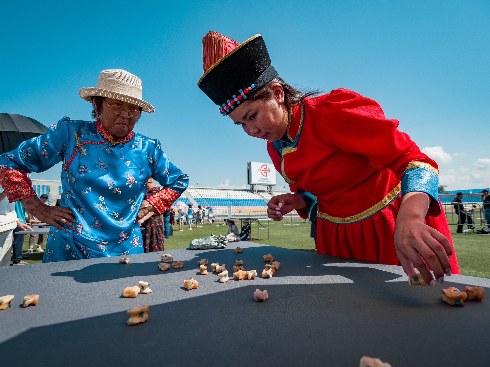 Guests of the festival get acquainted with traditional folk games. In the photo, a girl plays the game "Shagai Naadan".