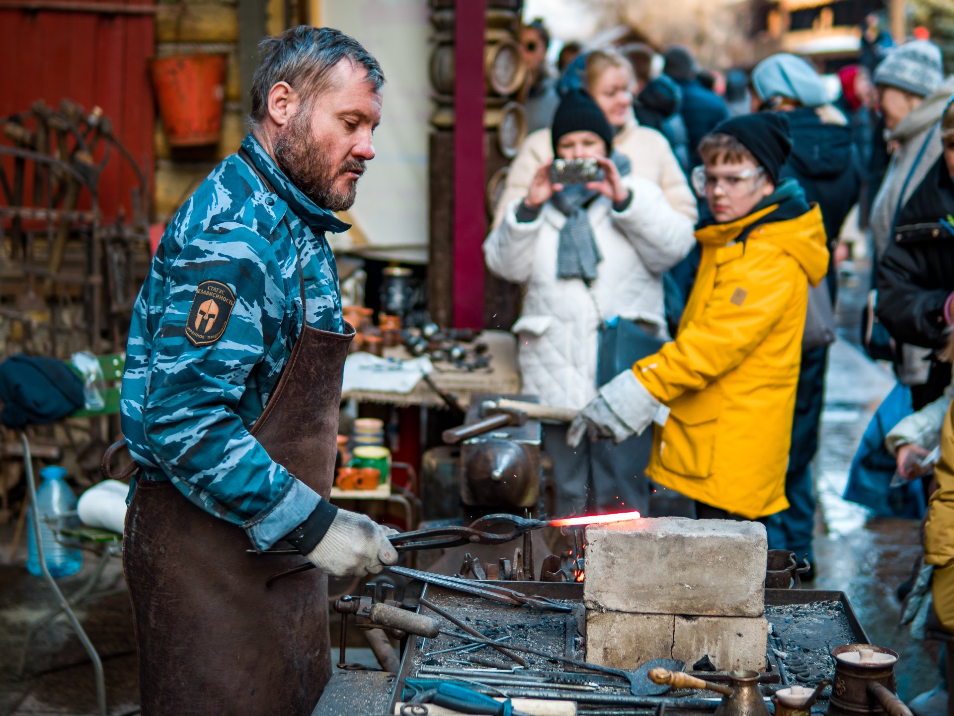 The blacksmith demonstrates the skill of working with hot metal.