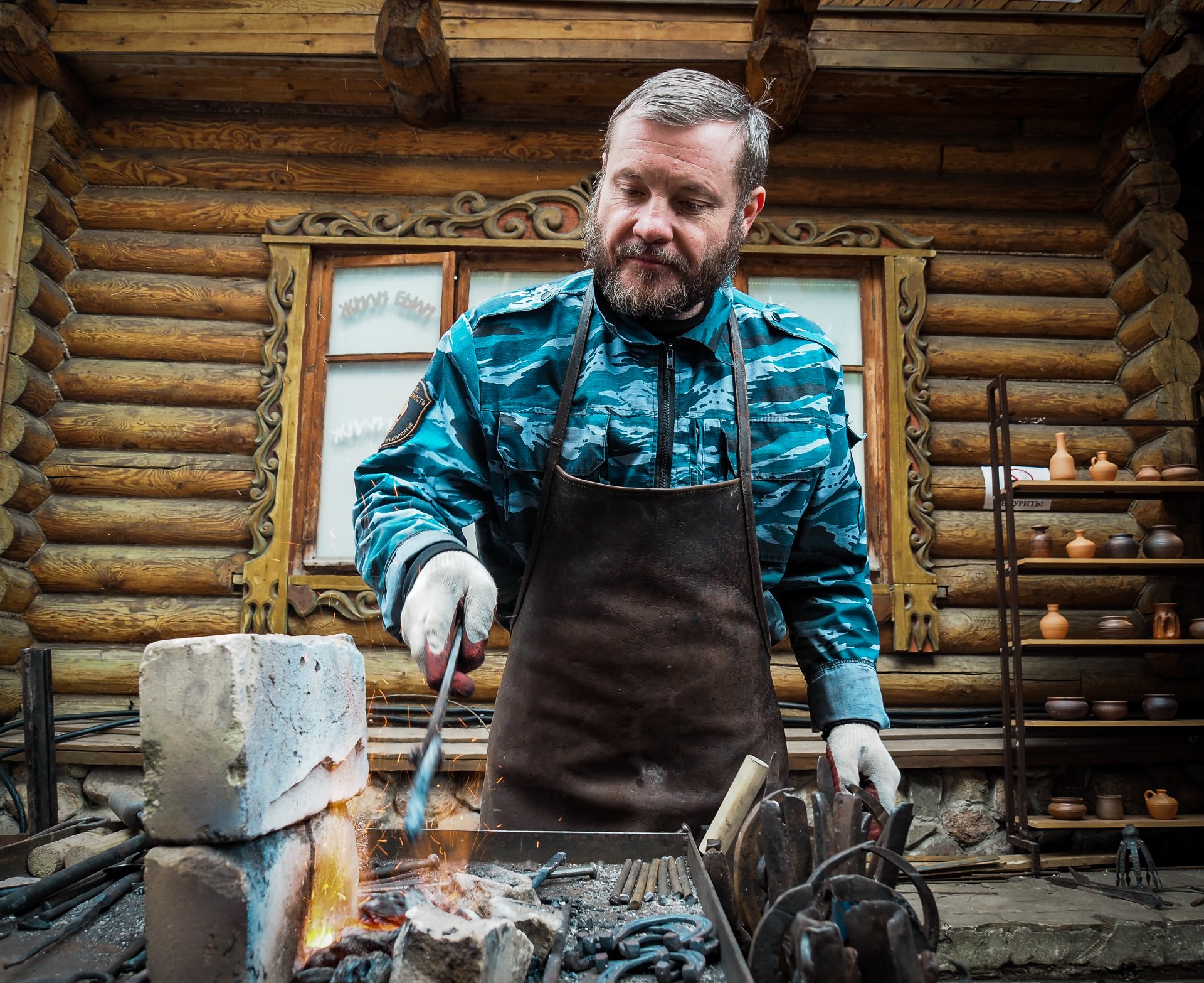 The blacksmith demonstrates the skill of working with hot metal.